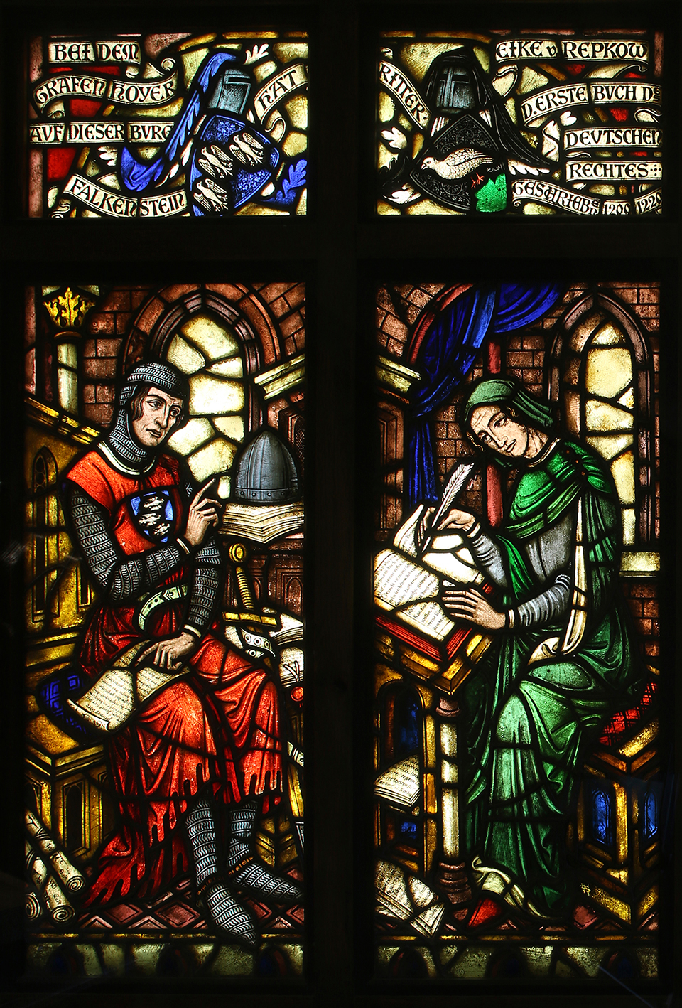 The glass window depicts Eike von Repgow and Count Hoyer II of Falkenstein: Hoyer II is awarding Eike the task of putting Saxon law in written form